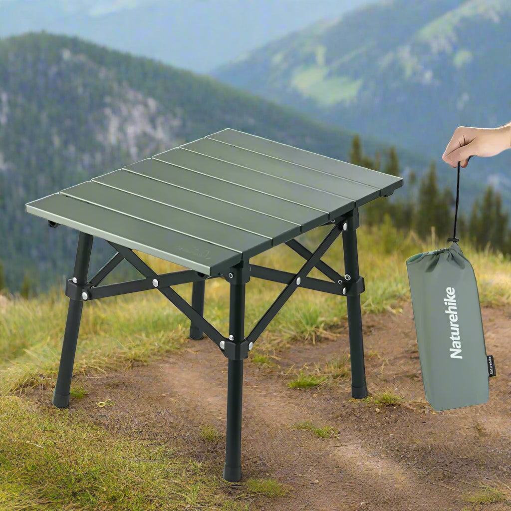 Green folding camping table with black legs and a matching carrying bag on a white background, featuring the Naturehike brand.